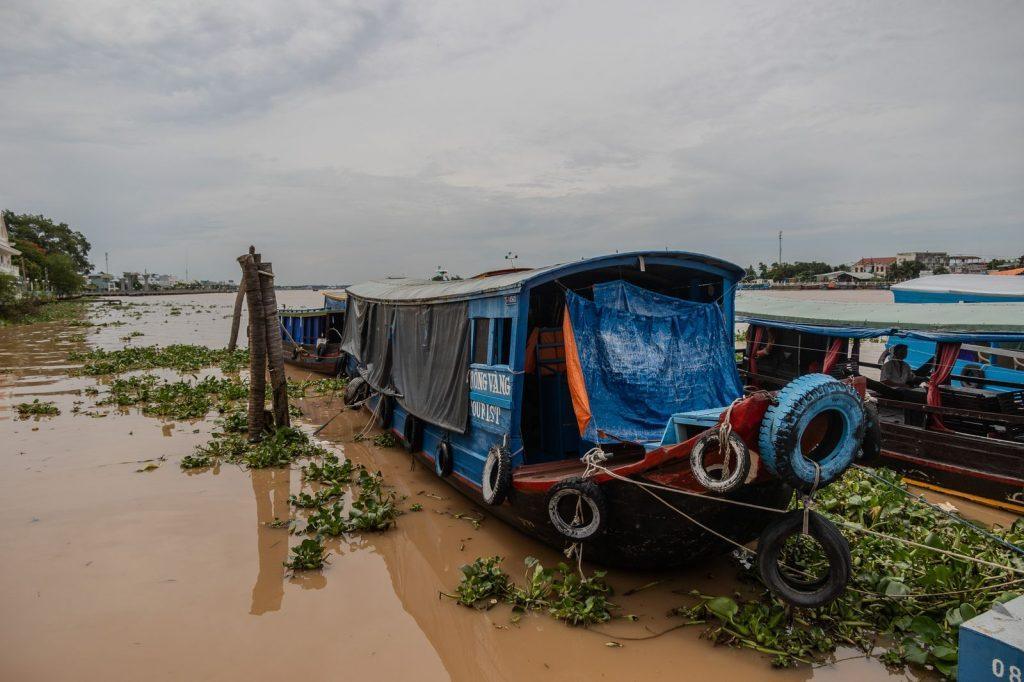 Blue boat moored near a quay on the river in the Mekong Delta in Vietnam