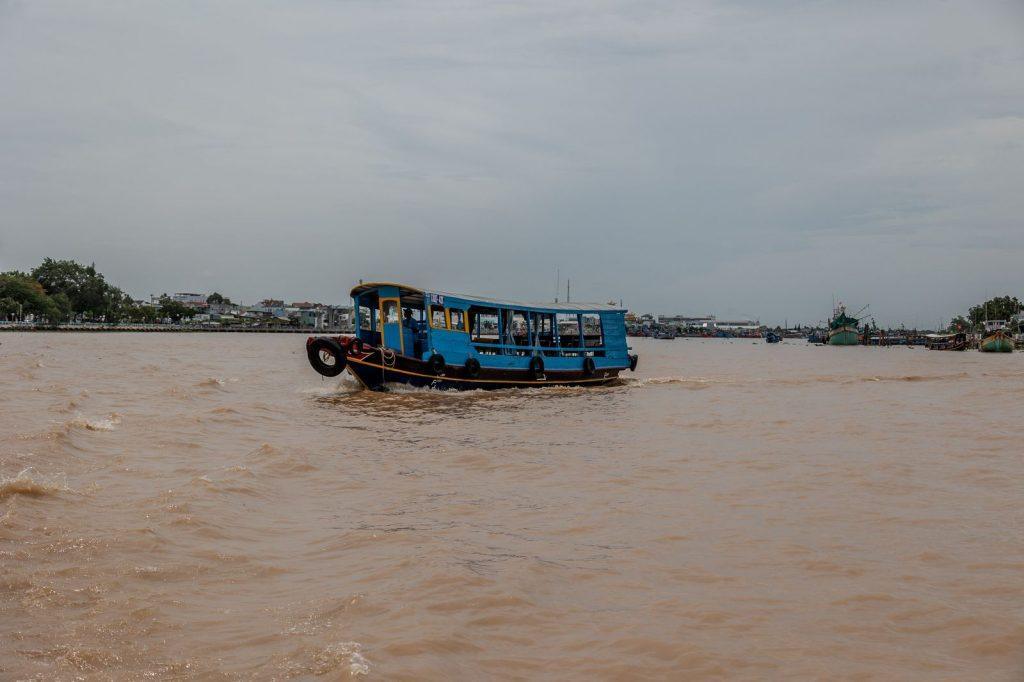 Blue transport boat sailing on the river in the Mekong Delta in Vietnam