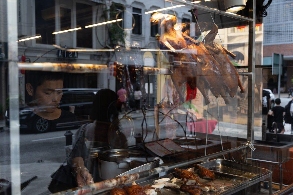 Street food stall in Kuala Lumpur with hanging roast ducks
