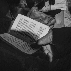 Mains tenant un petit livre de prières en balinais, pendant un rituel à Trunyan.