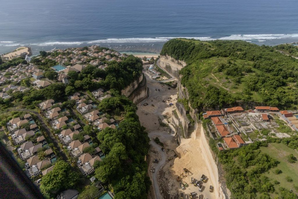 Visible human developments along a rocky coastline, modifying the relief between cliffs, built-up areas and shoreline.