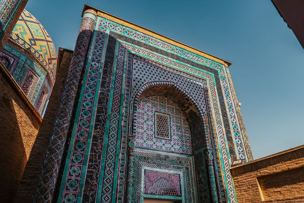 The entrance façade of Shah-i-Zinda in Samarkand is decorated with geometric mosaics and calligraphy from the Timurid era.