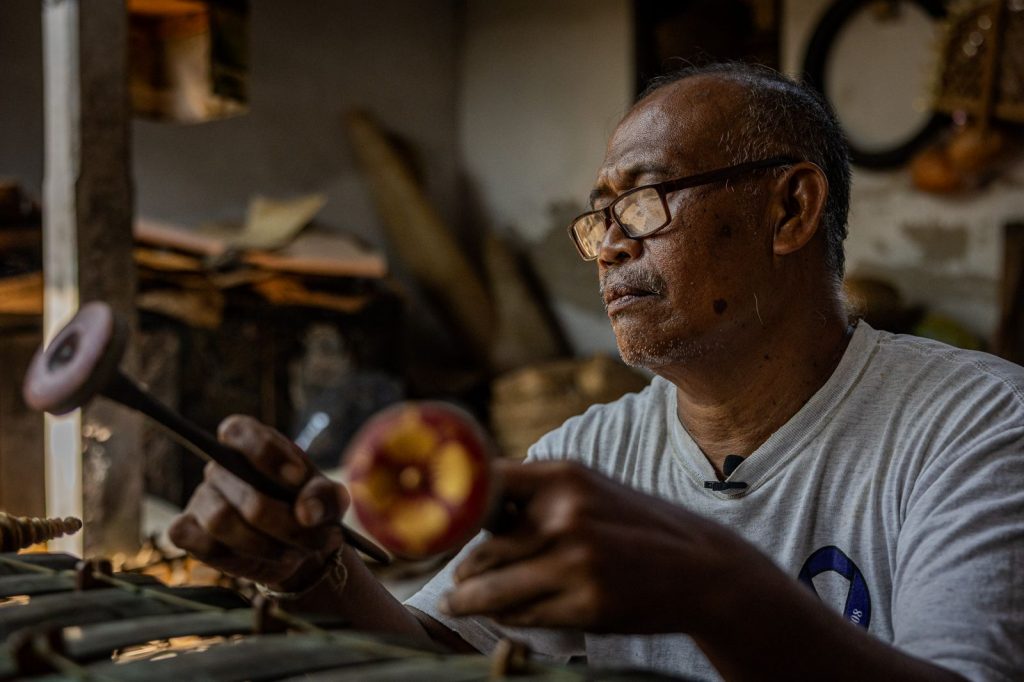 Dalang jouant du gamelan dans son atelier.