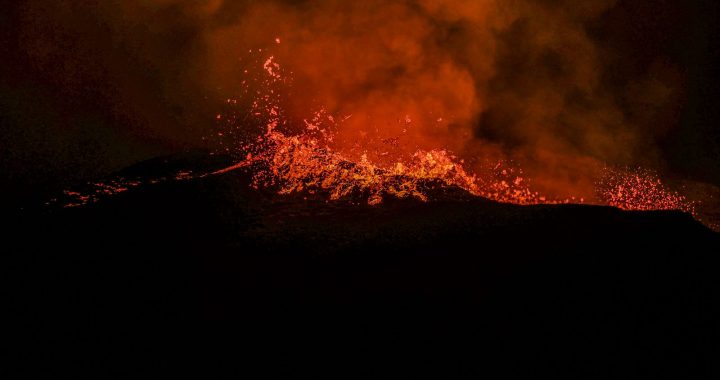 Éruption volcanique de nuit avec projections de lave et fumée