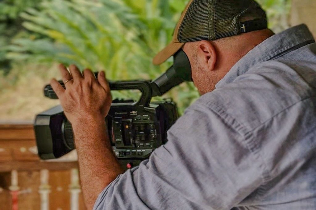 Documentariste filmant avec un camcorder dans un environnement tropical à Bali
