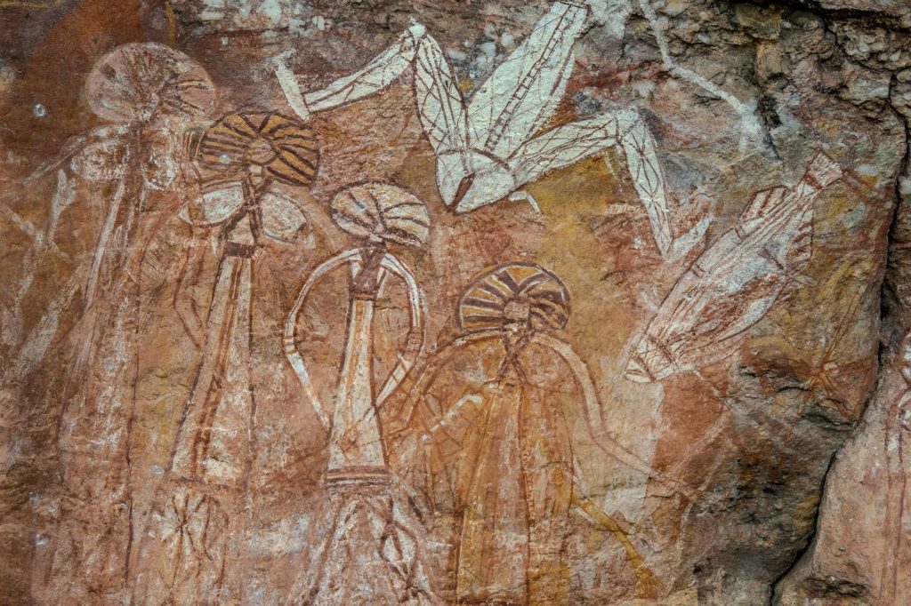 Peintures rupestres représentant des silhouettes humaines et des oiseaux sur une paroi rocheuse.