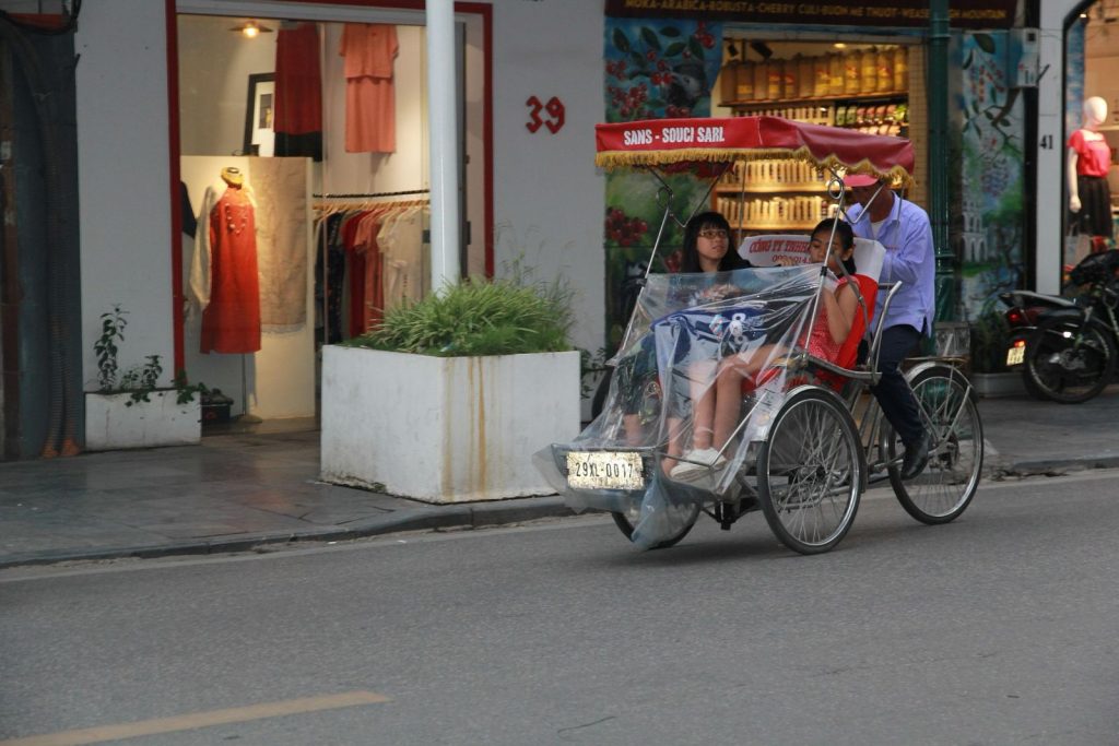 Cyclo transportant des passagers dans une rue de Hanoï au Vietnam.