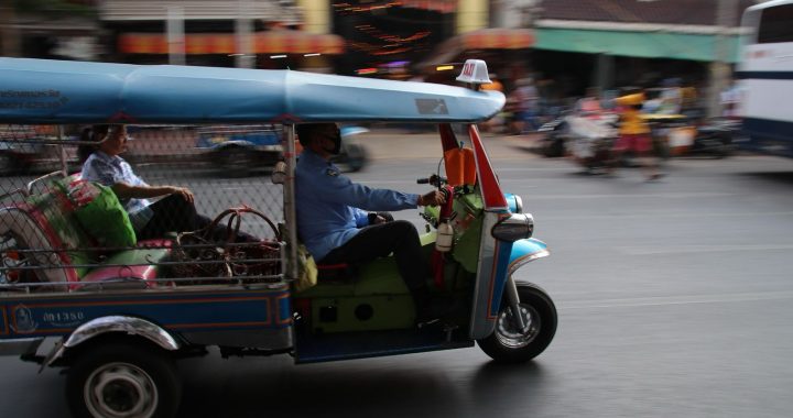 Tuk Tuk driving through a busy street in Bangkok, Thailand.