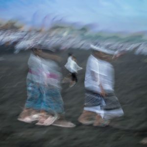 Balinese worshippers walking during a beach ceremony in Bali, Indonesia