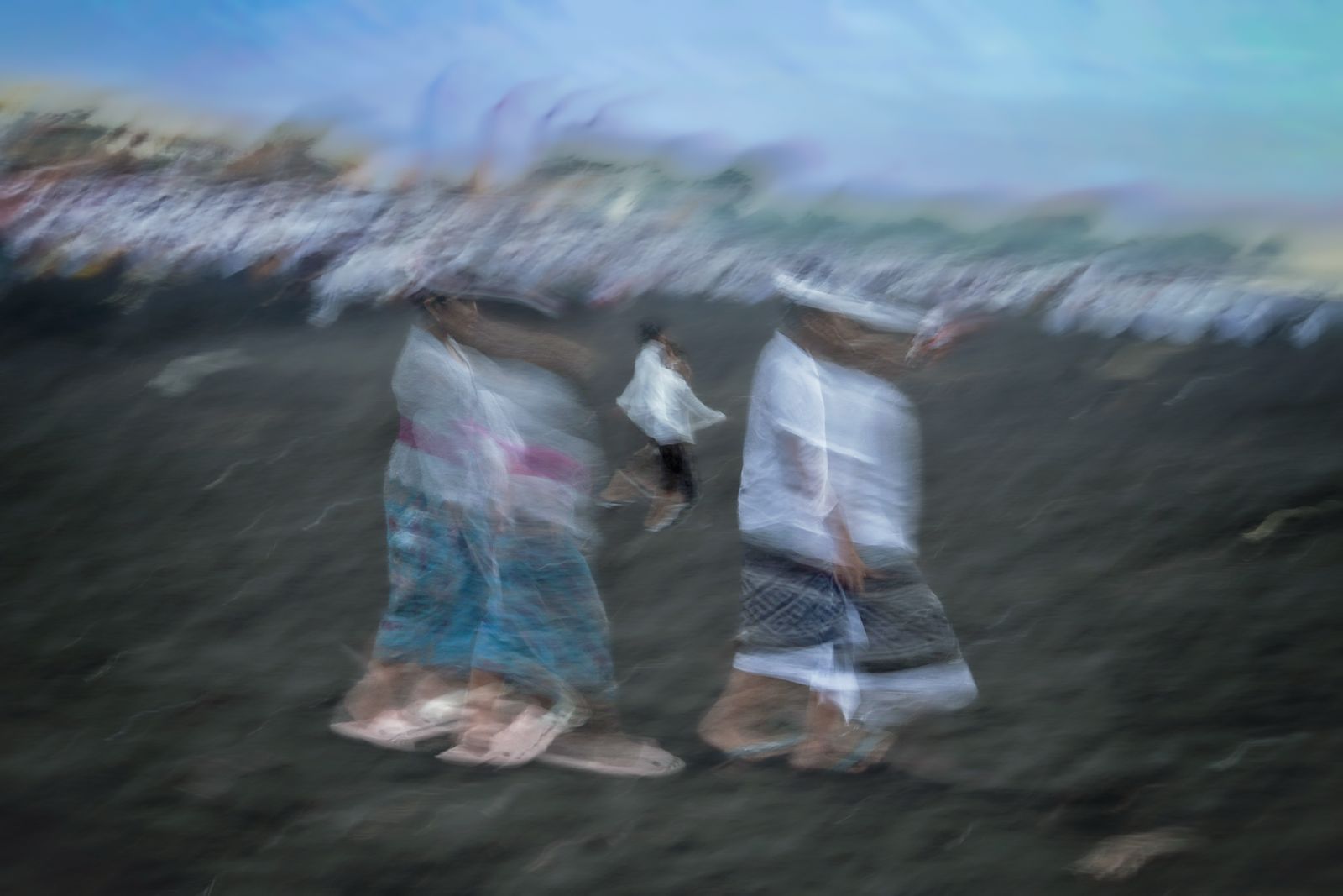 Balinese worshippers walking during a beach ceremony in Bali, Indonesia