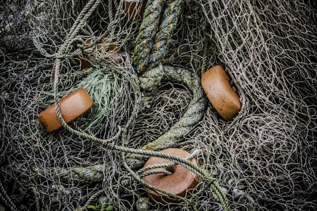 Close-up of tangled nylon fishing nets with ropes and floats.