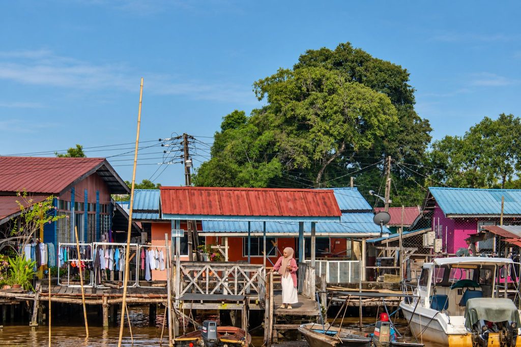 Riverside houses and small boats along a community settlement in Sarawak, Borneo.