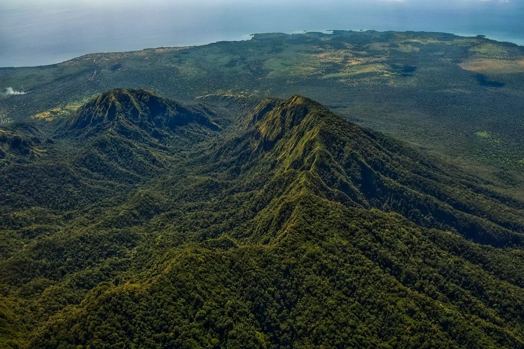 Aerial view of the forest-covered volcanic mountains of Baluran National Park in East Java, Indonesia.