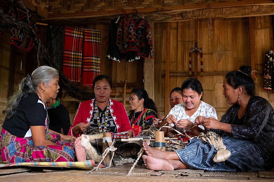 Women practising traditional weaving and craftsmanship as part of living cultural heritage.